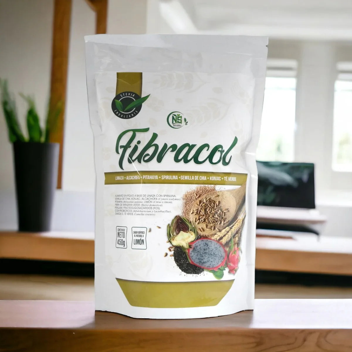 Paquete de suplemento FibraCol con ingredientes naturales como linaza, alcachofa, pitahaya y spirulina en mesa interior